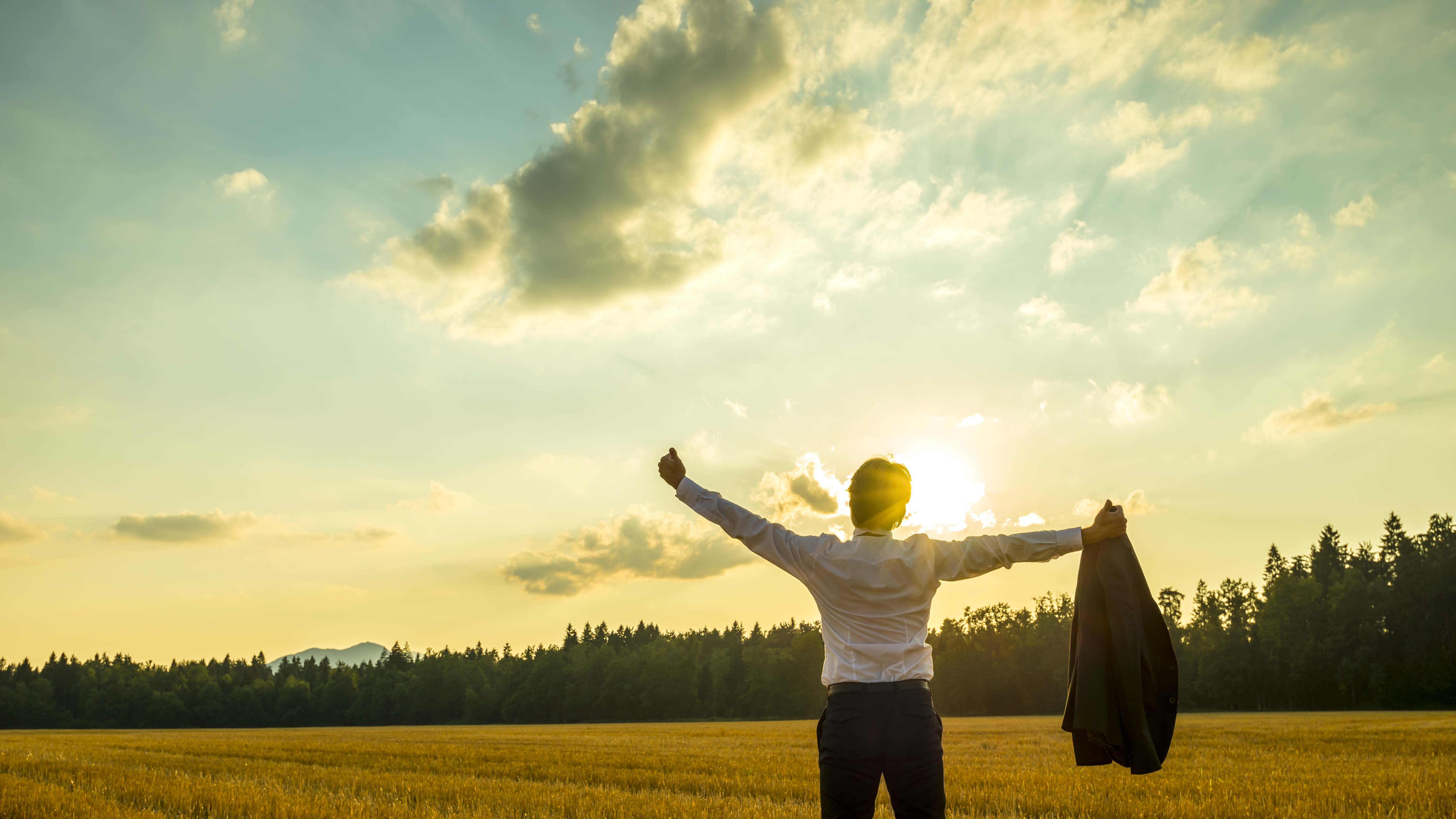 business person stretching sunset